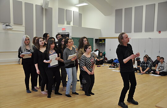 Un groupe d'étudiants répètent une scène de comédie musicale.