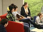 Des étudiants assis dans un fauteuil en discussion.