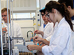 Une étudiante en laboratoire manipule une éprouvette.