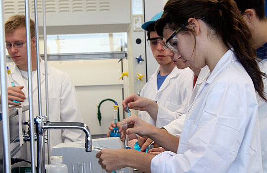 Une étudiante en laboratoire manipule une éprouvette.
