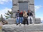 Un groupe d'étudiants posent devant un monument à Grosse Île avec des étudiants de la francisation.