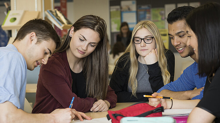 Des étudiants collaborent autour d'une table de travail