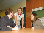 Des étudiants en discussion dans une fausse cuisine.