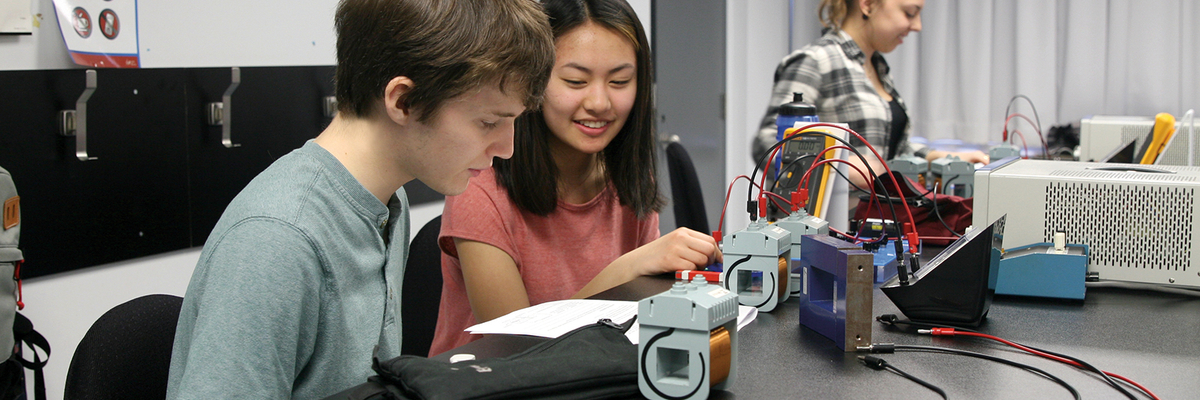 Deux étudiants travaillent sur un circuit électrique.