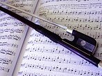 Un archet sur une partition de musique.