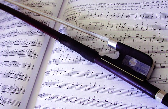 Un archet sur une partition de musique.